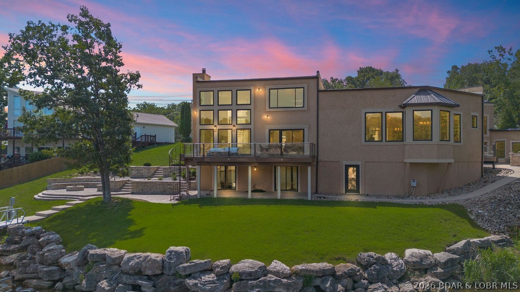 Luxury lakefront home located in a highly sought-after cove at Lake of the Ozarks, offering a private dock, indoor pool, and excellent entertaining spaces. This fully furnished, recently updated 5-bedroom property features an open-concept layout with expansive lake views and quality finishes throughout.
The main living area flows into a well-appointed kitchen with premium appliances, custom cabinetry, and solid surface countertops. Notable interior features include a spiral staircase, marble flooring, and updated lighting.
The walk-out lower level provides additional living and entertaining space, along with an indoor swimming pool for year-round use. A private guest suite with full bath offers added flexibility for hosting.
Exterior highlights include a custom outdoor kitchen and a private dock with an 18x50 slip and PWC lift.
Recent updates include a brand new roof with a 15-year transferable warranty, new marble flooring, updated lighting and more.
Ideal for full-time living, a second home, or investment property.