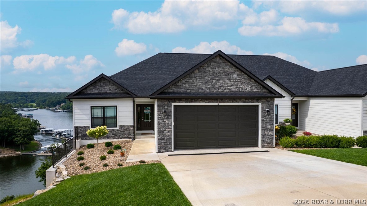 Prime Lake View Villa at The Villas at Tuscany! This barely used 4-bedroom, 3-bath, 2,930 sq. ft. villa offers the best view in the complex overlooking Libby Cove at the 1MM of Big Niangua. Built in 2022 this home features main-level living, two master suites, granite countertops, stainless steel appliances, hardwood floors, and professionally furnished décor. Enjoy outdoor living on large, covered screened decks on both levels while soaking in the lake views. The spacious primary suite boasts a custom walk-in closet and oversized tiled shower. An oversized 2-car garage provides plenty of room for lake toys. With a gentle driveway and a gated community this helps with ease. Community amenities include pool, pickleball, fire pit & pavilion, plus golf cart access with no steps to the dock. A 14x40 slip (A-8) with dock box in the list price, while a 16x44 slip (A-12) with a 8ft concrete fill and wet steps is available for additional purchase. Whether full-time or part-time, this no-maintenance setting offers the perfect balance of luxury, comfort, and lake living—just minutes from the iconic Four Corners! Sellers barely used as a summer getaway.