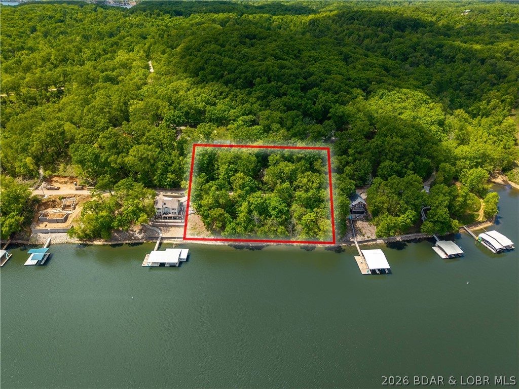 GREAT VIEW OF A LARGE COVE...(240 Lineal Feet) of lakefront...Cove Protection, Deep Water, Nice Neighborhood. Experience the perfect blend of tranquility and potential with this premier 0.79-acre lakefront lot located on Mimosa Road in the desirable Rocky Mount area. Nestled within the Walter Deem Ranch subdivision, this property offers an exceptional opportunity to build your dream retreat at the Lake of the Ozarks. This great lot features: Prime Lakefront with expansive views and direct access to the water. This calm water location is perfect for swimming off the dock. With nearly 0.8 acres of land, there is ample room to design a custom home that maximizes the natural topography and stunning vistas. Excellent Location: Located within the School of the Osage district and serviced by the Rocky Mount Fire Protection District. The neighborhood is established and quiet, perfect for those seeking a peaceful lakeside lifestyle.