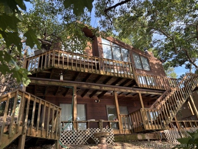 3BR/3.5 bath home located at the 50MM directly across the lake from Red Fox Restaurant.  Open floor plan with main level BR and full bath, laundry, kitchen/dining and Livingroom with soaring ceilings, fireplace and lots of windows to overlook the lake!  Deck also overlooks lake.  All new carpet and some new vinyl installed In August 2026.  Upper level includes 2 BRs and 2 full baths.  Lower level includes walkout, and large family room with bar/kitchenette area and a 1/2 bath.  Blacktop driveway with 2 car carport and 1 car detached garage and additional storage shed.  Deck needs some work and interior could use some paint, but otherwise a solid home and priced accordingly!