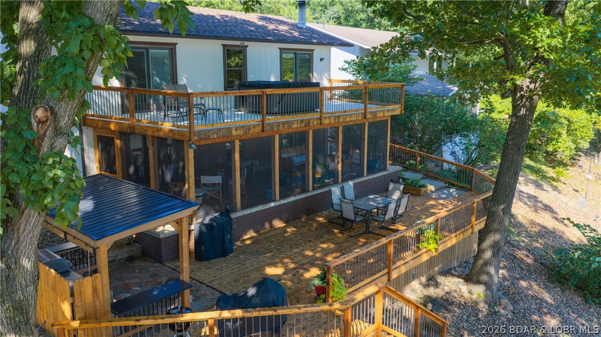 Lake front living at it's finest on the 36 Mile Marker.  Experience the perfect blend of comfort and breathtaking lake views in this exceptional lakefront home.  With cove protection and stunning views of the main channel, this property offers the ideal setting for both relaxation and recreation.  This beautiful homes features 2 spacious guest bedrooms, full bathroom, and the large primary en suite - all bedrooms have a lake view.  On the lower level, the large living room is perfect for entertaining and relaxing. The beautifully remodeled kitchen features new cabinets, countertops, flooring, island workspace, and a convenient walk-in pantry.  The living area extends outside with the newly remodeled screened-in deck-Oh the view!! The outdoor kitchen is next to the sun deck for all you cooking enthusiasts - yes please!  Easy steps down to the private 2-well dock with swim platform making it easy to spend your days boating, swimming, and fishing.  The view is fantastic!  Whether you are looking for a full-time residence or a weekend retreat, this lake front beauty delivers the ultimate waterfront lifestyle - meticulously maintained and ready for you to enjoy!