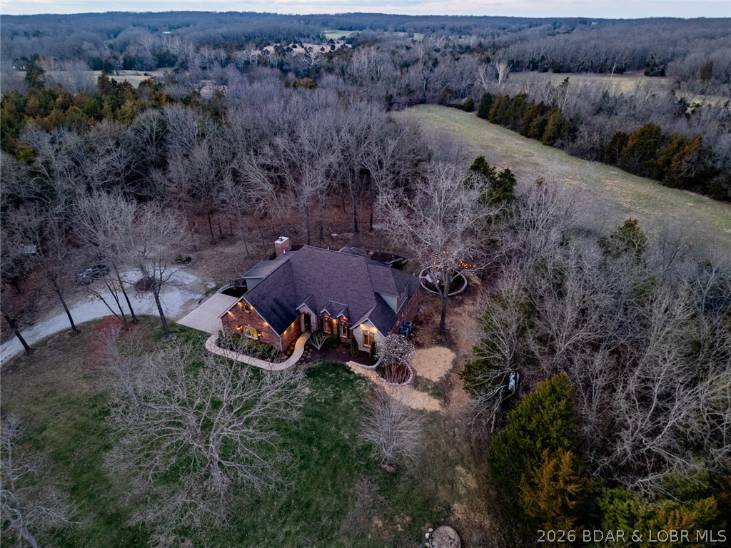 Escape to a private country estate in the heart of Missouri wine country, ideally located between St. James and Rolla. Set on more than 25 scenic acres of pasture and mature trees, this meticulously maintained 5-bedroom, 3 full-bath, 3 half-bath brick and stone 1.5-story home offers privacy, craftsmanship, and exceptional space for entertaining. Designed in classic French Country style, the home features hand-scraped hardwood floors, painted custom cabinetry, white trim, and warm designer finishes throughout. Step directly onto the screened porch to enjoy seasonal views and fresh country air. The main-level primary suite offers comfort and convenience with property views, a built-in workstation, dual-sink vanity, jetted tub, walk-in shower, private water closet, and spacious walk-in closet. The walk-out lower level expands the living space with stained concrete floors, a fifth bedroom, full bath, wood-burning fireplace, mini-kitchen, and a large recreation. Outside, enjoy professional landscaping, a stone fire pit, and endless possibilities across 25+ acres, making this custom estate property a rare opportunity for privacy, recreation, or hobby farming in central Missouri.