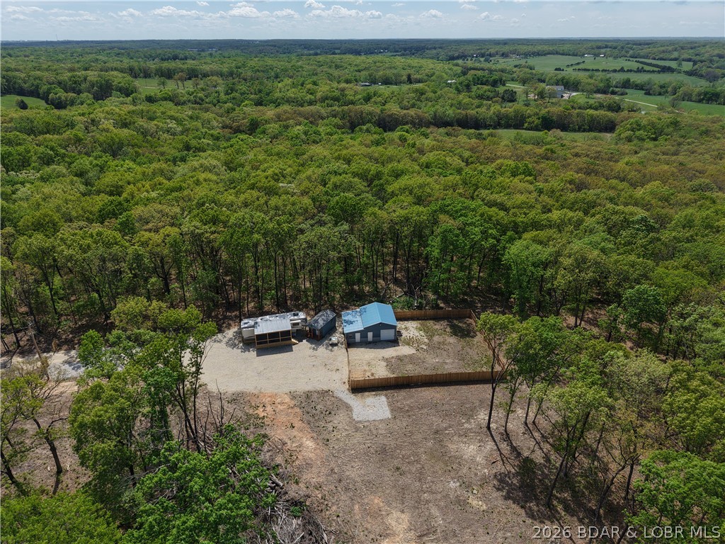 BACK ON THE MARKET AT NO FAULT OF THE SELLER. This isn’t some cookie-cutter place—you’re getting 5 acres that work for you. Everything’s already handled. Utilities are in, brand-new well & lagoon are done, CoMo wifi & there’s a solid setup in place so you’re not dumping money into the basics before you even start. You can roll in day one & use it. The  2013 38’ Forest River Creek fifth wheel is clean, roomy, & dialed in—plenty of space to crash, cook, and relax. It’s not roughing it, it’s comfortable. That screened-in porch? That’s where your mornings start & your evenings wind down. The 10x20 she-shed comes complete with a mini split. Now the real win—the 25x32 shop. Epoxy floors, fully insulated, mini-splits on both sides, & water already hooked up. This isn’t some tin shed- this is a legit space. Garage, workshop, hangout, or even finish it out for more living area—it’s ready for whatever you’re into. & the land? Flat, usable, & private. Room for toys, a firepit, a garden, or eventually building exactly what you want w/out being rushed into it. Bottom line—this place gives you options. . No projects you have to do—just a solid setup & 5 acres to make your own.