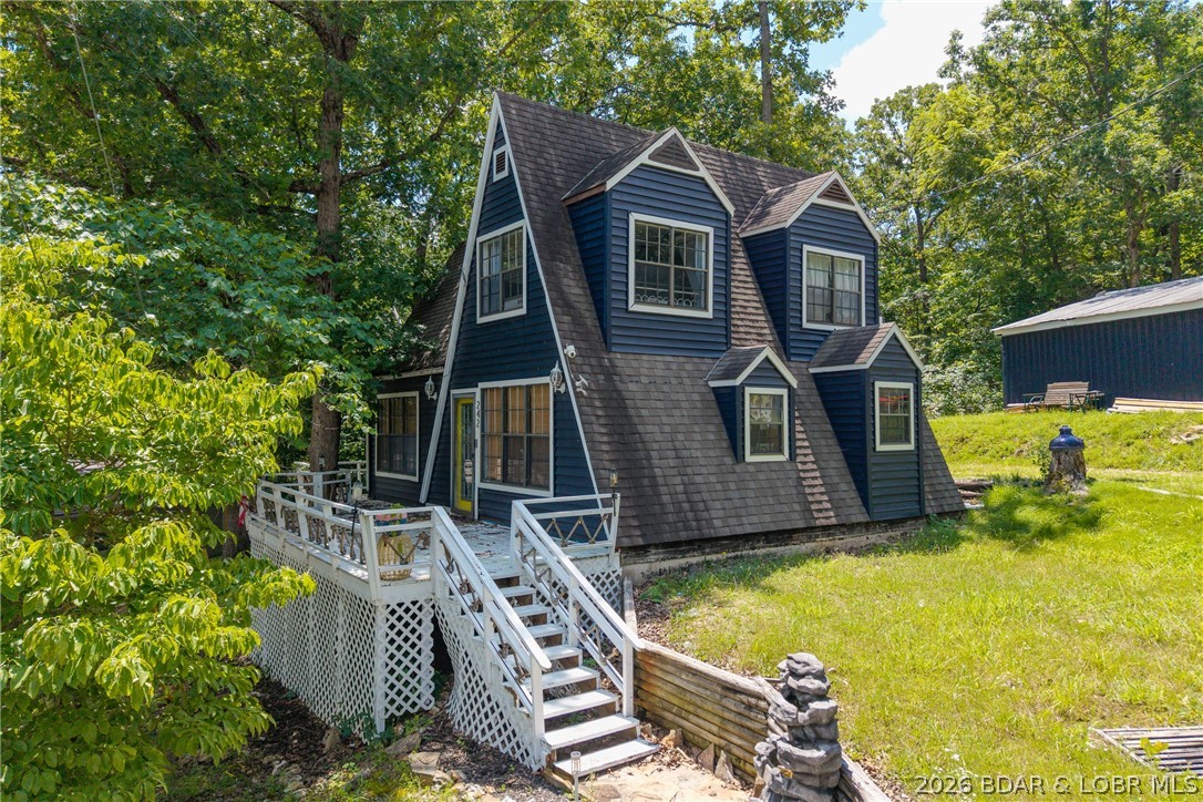 Freshly remodeled, turnkey, 2-bedroom, 2-bath A-frame with a spacious loft, sunroom, and oversized 2-car pull-through garage, just steps to the lake with NO HOA! This charming retreat sets on nearly half an acre with no neighbors behind or on one side for added privacy. Inside, LVP & engineered hardwood flooring flow throughout the home. The main level features an open living area and primary ensuite, while the spacious upper level offers a second bedroom, second full bath, laundry, and versatile loft space—ideal for additional sleeping quarters or flex space. The sunporch is a true highlight, and furnished for comfortable lounging or entertaining. Step outside and enjoy the privacy of the generous lot, along with an oversized 2-car detached pull-through garage with plenty of room for vehicles, lake toys, and storage. Lake access is convenient, with multiple community boat ramps nearby, including one directly across the street. Whether you’re looking for a full-time residence, weekend getaway, or investment property, this one delivers style, space, privacy, garage capacity, and convenient lake access! Come see why this charming A-frame is ready to become your next lake escape!