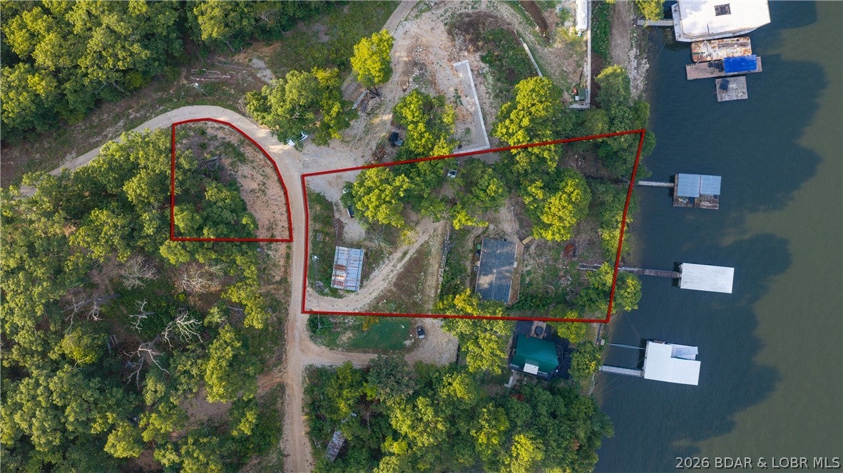 Lake of the Ozarks Waterfront Home with Private Boat Dock & Nightly Rental Potential! Discover incredible value in Barnett’s sought-after Golden Beach subdivision! Situated on a spacious double lot with 136 feet of prime shoreline directly across the channel from Coconuts at the Lake, this 3-bedroom, 2-bathroom lakefront property offers the ultimate waterfront lifestyle. Modernized inside and out, recent upgrades include brand-new siding, windows, PEX plumbing, LVP flooring, LED lighting, dishwasher, refrigerator, and a refreshed HVAC system. Enjoy effortless main-level living, a spacious covered deck overlooking the water, a private covered boat dock with electric (10x30 and 32x18 slips), and a detached garage/workshop. With no HOA restrictions and flexible short-term/nightly rental rules allowed, this property makes an exceptional vacation rental, investment, or personal refuge. Includes an additional lot section across the street for extra parking or privacy!