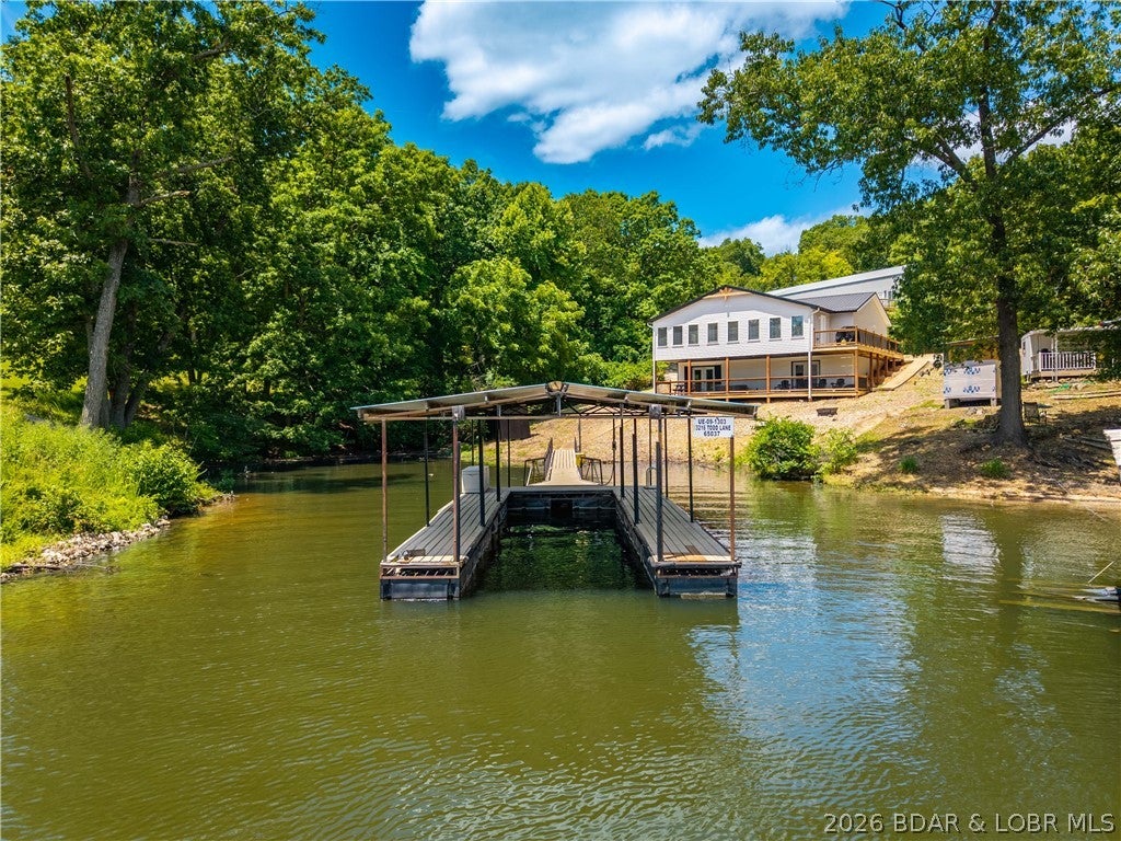 Lakefront living on 2 private acres at the 8MM near Laurie! Nestled in a protected cove with a gentle walk to the dock, this beautifully updated home offers the perfect combination of comfort, privacy, and convenience by both land and water. Enjoy easy access to popular lakefront destinations including Shady Gators, Tap & Grill, Franky & Louie's, and Lake Burger. The main level features an open-concept design centered around a stunning new kitchen with a large gathering island, ideal for entertaining family and friends. Main-level living includes 3 bedrooms, 2 full baths, and a laundry room. Recent updates include luxury vinyl plank flooring, fresh paint, stylish lighting, and beautifully remodeled bathrooms. The walkout lower level provides additional space for guests with a private en-suite bedroom, pool table area, and comfortable family room opening to a lakeside deck. New decking and quality finishes throughout make this property truly move-in ready. With ample parking, a prime lake location, and modern updates from top to bottom, this is the ideal lakefront retreat for full-time living or weekend getaways.
