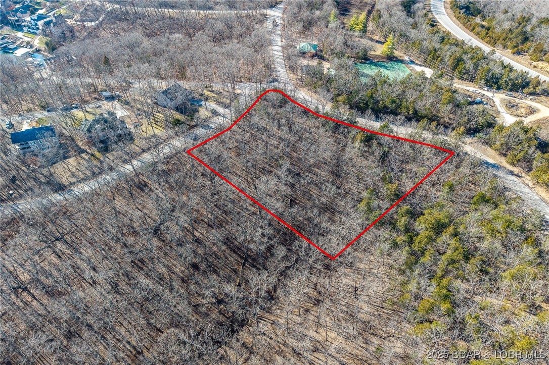 Surrounded by mature trees and natural Ozarks beauty, this wooded lot at The Villages at Shawnee Bend offers a peaceful, private setting within one of Lake of the Ozarks’ most distinguished communities. From the moment you arrive through the grand waterfall entrance, the neighborhood’s upscale character is clear. Residents enjoy access to a beautifully appointed clubhouse, resort-style community pool, championship tennis courts, and pickleball facilities, along with parks, and playgrounds. Paved roads and underground utilities make building seamless while preserving the natural landscape. Ideal for a custom home or lake retreat, this wooded homesite blends serenity, luxury, and an active lake lifestyle.
