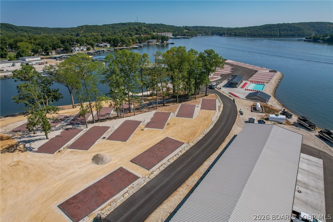 Welcome to Paradise Point RV Resort—one of the most exciting opportunities to own at the 38MM of Lake of the Ozarks. Set on a stunning peninsula with incredible panoramic views, this development offers both lakefront & second-tier RV lots now available for individual purchase. Every site is built right—level concrete pads with full hookups including 100-amp electric, water, sewer, and Wi-Fi—designed for comfort, convenience, & long-term value. An HOA ($200/month) keeps the community maintained and looking sharp. The amenities set this apart: lakefront pool, sandy beach, swimming dock, marina with boat slips available, covered pavilion with grills, large stone fire pits, bathhouse with laundry, and fenced dog park. Whether you want to relax or entertain, it’s all here. Leave your RV on-site year-round and skip the hassle of hauling. When you’re not using it, rent it out for additional income—strong demand makes this a smart investment as well as a lifestyle play. Located in Sunrise Beach with easy access by land and water, this is lake living without the typical price tag or maintenance. Multiple lots available with varying prices—secure your spot now before they’re gone.