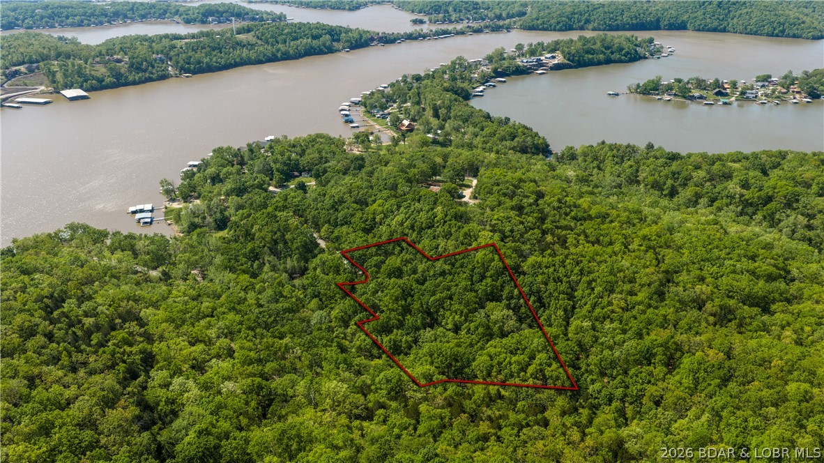 Tucked away in the peaceful Grandview Heights Subdivision, this 4.68-acre property offers a rare combination of privacy, space, and lake access. With a partial view of the Little Niangua Arm, you get just enough water scenery to remind you why you’re here—without sacrificing the seclusion that’s getting harder to find. This property is all about potential. Whether you’re envisioning a custom home, a weekend retreat, or an investment play, the groundwork is already here. A community dock with an included boat slip sits just minutes away, giving you quick and easy access to the lake without the premium price tag of full waterfront. An existing structure is on site and is considered uninhabitable, but it opens the door for a fresh start—build exactly what you want, exactly how you want it. If you’ve been looking for acreage, privacy, and lake lifestyle all in one package, this is where the conversation starts.
