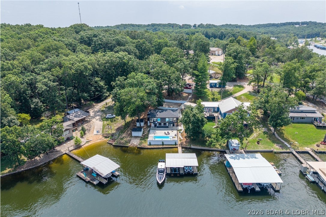 STUNNING, UPDATED LAKEFRONT OASIS IN AN UNBEATABLE LOCATION! 4-bedroom, 3-bath retreat is perfectly positioned in one of the most coveted coves at Lake of the Ozarks—just around the corner from the ever-popular Franky & Louie’s Beachfront Bar & Grill. Set on a gentle, flat lot with breathtaking panoramic water views and effortless lake access that truly captures the best of lake living. Start your mornings on the expansive deck overlooking the water, spend your days boating, swimming or relaxing in the calm, protected cove and unwind in the evenings with unforgettable sunset views. Enjoy the ultimate outdoor lifestyle with an in-ground pool and private dock—perfect for soaking up the sun, entertaining guests or heading out on the water at a moment’s notice. With ample parking and a highly desirable layout, this property is ideal as a full-time residence, weekend getaway or income-producing vacation rental. The combination of location, amenities, and setting makes this a rare opportunity to own a true lakefront gem in one of the most sought-after areas. Lakefront properties like this don’t come along often—start living the lake life you’ve been dreaming of! WELCOME HOME!