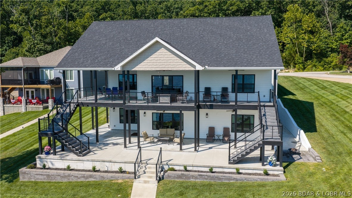 This gorgeous lakefront home truly has it all. Built in 2023, this 3,368-square-foot showstopper offers 5 spacious bedrooms & 3.5 baths, thoughtfully designed for comfort, entertaining & exceptional lake living. Nestled in a quiet, upscale neighborhood at the coveted 42 MM, it captures sweeping lake views & boasts an impressive 113 feet of pristine shoreline. Quality craftsmanship is evident throughout, featuring Diamond Kote smart siding, composite decking, aluminum railings, concrete driveway & a wraparound covered concrete patio & deck—all designed for low-maintenance living. The flat, beautifully landscaped yard features a rip rap seawall & an exceptionally easy walk to the water, with only a couple stairs from the lower patio to the dock with plenty of room for a pool. The concrete 3-well dock includes a swim platform & 8x10 storage area, making lake days effortless. A 3-car garage, quality custom construction & thoughtful details complete this exceptional property. The 5th bedroom is currently used as a workshop but could easily be converted with an en suite bath. From the peaceful setting to the stunning views, this immaculate lakefront retreat checks every box & then some!
