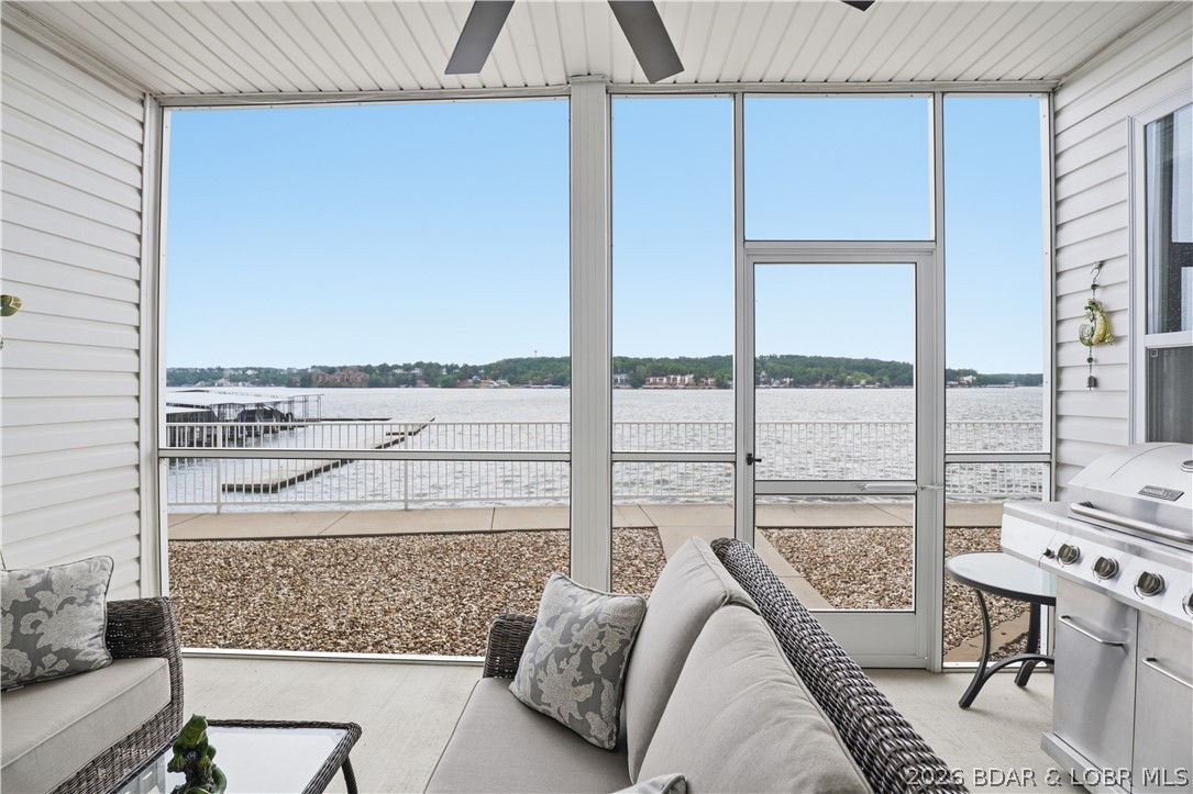 Experience elevated lake living in this rare lakefront condo located on the only island community at the Lake of the Ozarks. This turnkey unit offers unmatched convenience and lifestyle, featuring two boat slips just steps from your back door—perfect for effortless days on the water. Designed for both relaxation and entertaining, the condo boasts a walkout layout that leads directly to the boardwalk, placing you just moments from the pool and docks. Enjoy unobstructed, panoramic views of the main channel from your private space, creating the ideal backdrop for morning coffee or sunset evenings. Sold fully furnished, this property is truly move-in ready—ideal as a personal retreat, vacation home, or investment opportunity. With its prime location, seamless water access, and exceptional views, this is a rare opportunity to own a piece of lakefront island living at its finest.
