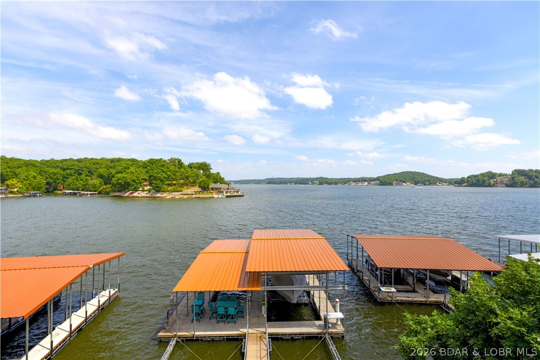 21259 Jade Dr in Rocky Mount is ready for lake days, weekend getaways, and effortless entertaining. Set at the 5 MM with 50 feet of waterfront, this furnished 4 bedroom, 2.5 bath walkout home captures beautiful main channel views from bright living spaces and multiple decks. Enjoy morning coffee overlooking the water, evenings on the covered deck, and easy days at the 2-well covered dock with 14x40 and 12x30 slips. Updated in 2021, the home offers wood floors, central air, attached garage, community water, sewer district, internet availability, and rentals allowed. Most furnishings, appliances, washer, dryer, and dock are included per inventory, making this Lake of the Ozarks retreat ready to enjoy.