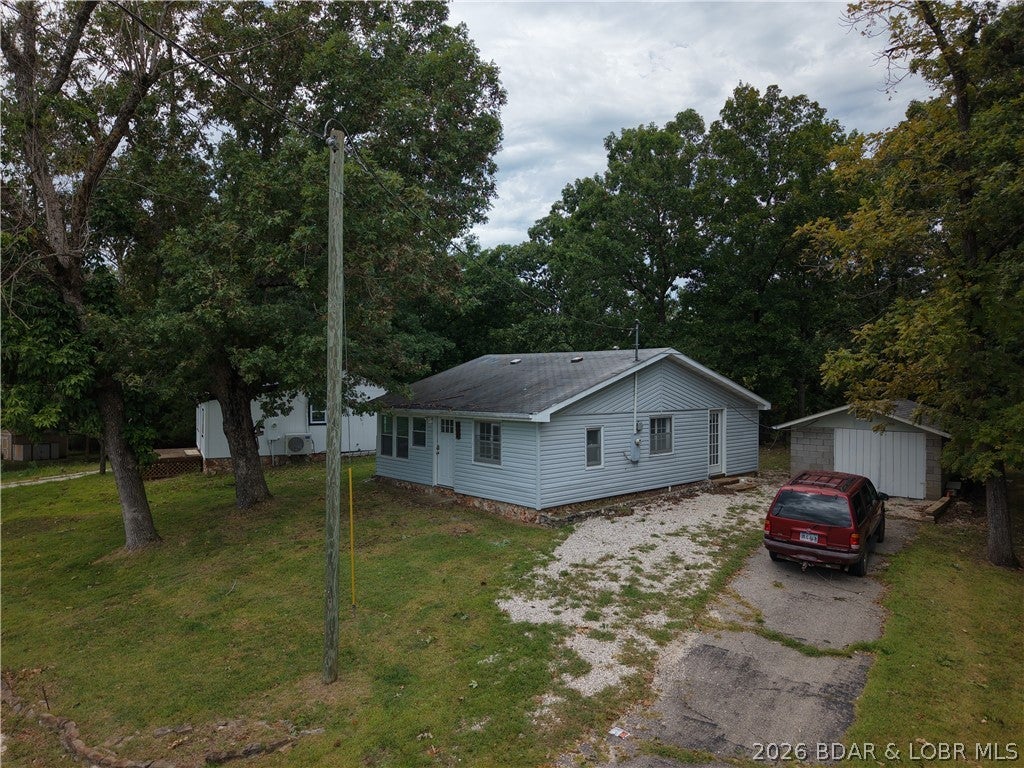 Enjoy lake-area living without the lakefront price tag! This charming 2-bedroom, 1-bath lakeview cabin offers a peaceful setting with Lake of the Ozarks views from both bedrooms and convenient lake access nearby at Station 46. Inside, you'll find granite countertops and a large utility/storage room providing plenty of extra space for lake gear, tools, and everyday storage. Outside, an asphalt driveway and detached garage add even more convenience and storage. Located in a quiet neighborhood, yet just down the road from Big Dick's Halfway Inn for food, drinks, and entertainment. Whether you're looking for a full-time home, weekend lake getaway, or an affordable place to enjoy everything the Lake of the Ozarks has to offer, this cabin packs a lot into a comfortable package.