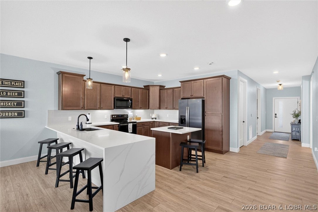 PANORAMIC VIEWS. DESIGNER STYLE. COMPLETELY TURNKEY. Welcome to Topsider, where modern lake living feels effortless in every season. This beautifully furnished 3 BR, 3 BA condo offers comfort, style and an unforgettable Lake of the Ozarks backdrop. Expansive lakeside glass fills the open living area with natural light, while glass panels on the spacious covered deck preserve the panoramic view and invite in even more sunlight. Watch the Lake change with the seasons, enjoy morning coffee or relax beside the electric fireplace. The kitchen features one of Topsider’s most unique layouts, with quartz countertops, stainless appliances, abundant cabinetry and additional working counter space designed for entertaining and everyday function. The lake view primary suite offers private deck access, dual vanities and a tiled walk in shower. Two additional BRs provide comfortable space for family and guests. Ideal for year round living, a personal retreat or investment opportunity, Topsider offers 2 lakefront pools, elevators, clubhouse, fitness center, playground, BBQ areas and pet friendly green spaces. Boat slips are available. Come for the view and stay for the lifestyle!