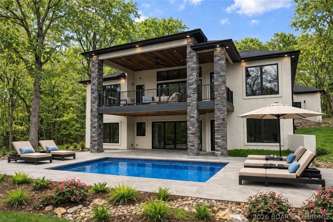 Welcome to your new modern retreat in Porto Cima. This stunning 4 bed, 3.5 bath home features three fireplaces, striking architectural details, and an open layout perfect for entertaining. The exterior makes a statement with sleek glass 8x10 garage doors and an extended 80-ft concrete driveway. Inside, you’ll find a seamless flow between living spaces, designer finishes, and warm gathering areas centered around multiple fireplaces. An additional lot provides extra privacy, room to expand, or space for a future pool with the hook ups already available. The impressive 80-foot concrete driveway offers ample parking and a grand approach to the home. There is a seperate exterior side entry to large crawl space storage and HVAC. A rare opportunity to own a fresh, modern build in one of the Lake’s most sought-after communities. Rendering of an optional pool in pictures.