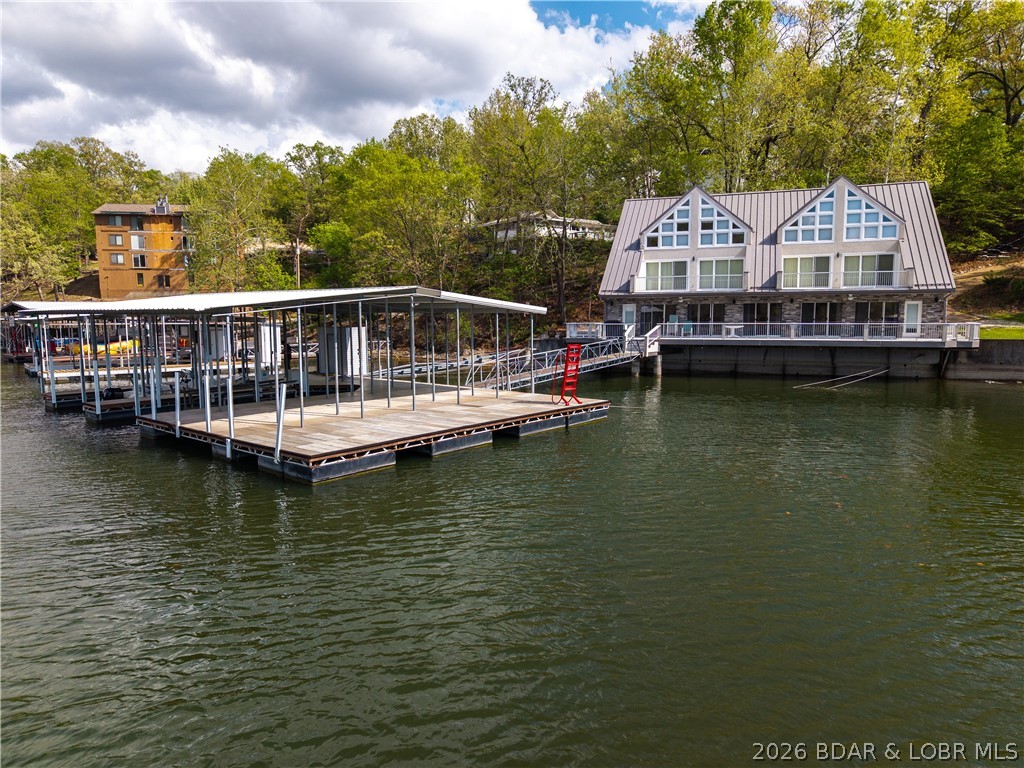 Back on Market at NO fault of Sellers- Perched right at the water’s edge, literally as close as you can get, this lakefront retreat delivers the lifestyle buyers come to the Lake for! Newly remodeled, this 6-bed, 5.5 bath home offers 3 levels of living space designed for both entertaining & relaxation plus cantilevered deck feels like your "floating". This deep water, no wake cove gives perfect balance of big views, calm water, while outdoor space maximizes guest's enjoyment. The private dock with swim platform is summer ready with 2 wells, hoist & potential to convert to 3rd slip. A unique & rare layout with excellent flexibility for multi-family use, featuring a shared wall design with separate bedroom wings on main floor & dual staircases leading to private upper-level bedrooms. This setup is ideal for 2 families to comfortably share the home while maintaining their own privacy. Nightly rental friendly & comes furnished as shown- so whether you're looking for a vacation rental or personal escape, this open main floor makes hosting large groups effortless. Near Bridgeview Marina 24hr gas dock, Dog Days & the new Oasis, this location delivers the best of Osage Beach entertainment
