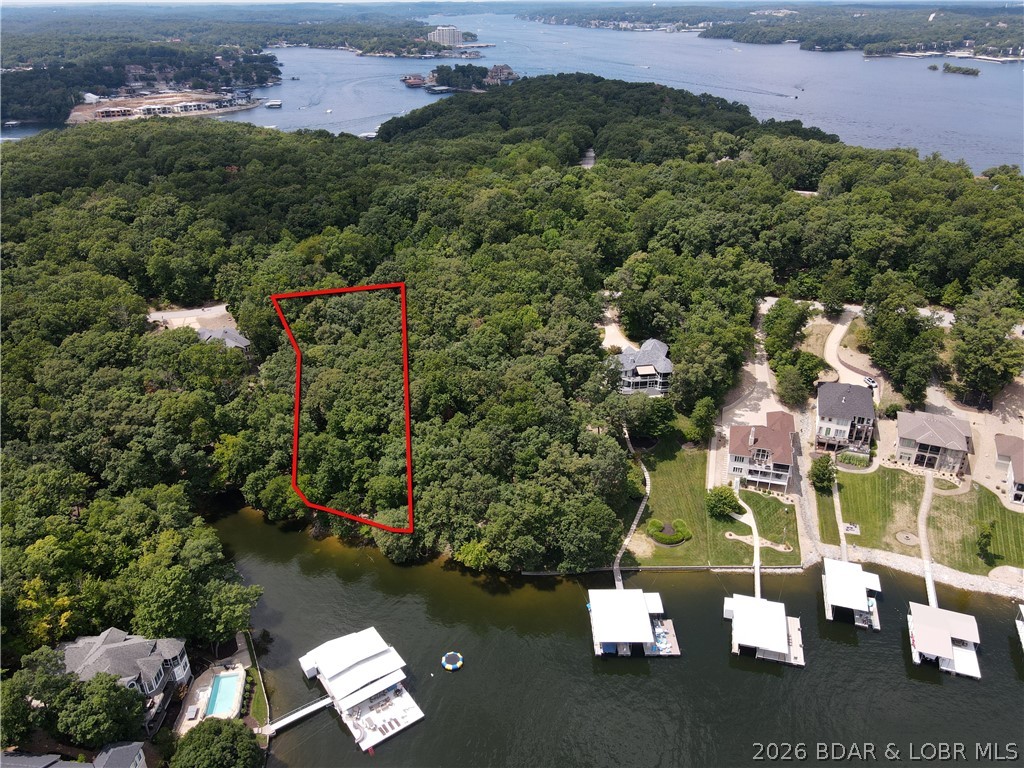 Discover the opportunity to build your dream home on this beautiful 1-acre homesite with 112ft of lakefront in the prestigious Porto Cima community. Surrounded by mature hardwoods, this private lot provides the perfect setting for a custom residence while blending seamlessly into the natural beauty of the Lake of the Ozarks. The POA requires a minimum home size of 1,500 square feet, ensuring the quality and character of the surrounding neighborhood. Property ownership includes access to an impressive selection of amenities, including community swimming pools, a fitness center, tennis and pickleball courts, and all of the highly desirable Four Seasons amenities. For those seeking an elevated lifestyle, optional memberships to the Porto Cima Club are available for an additional fee, offering championship golf, fine dining, and exclusive club privileges. Whether you're ready to build now or planning for the future, this exceptional lot offers the ideal combination of privacy, luxury, and endless potential.