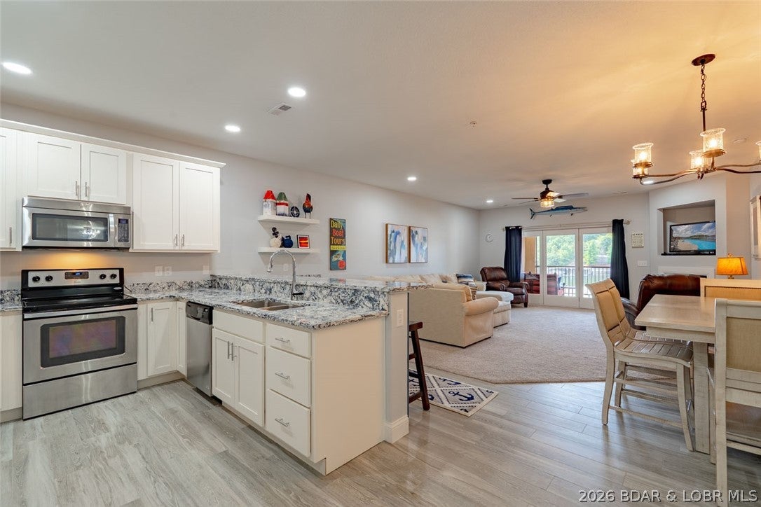 THIS is the Tuscany condo you have been waiting for—beautifully renovated, fully furnished, and complete with a 12x32 boat slip AND PWC slip.  This impressive 3-bedroom, 2-bath condo was substantially renovated in 2023, offering a fresh, upscale feel while being completely move-in ready.  Thoughtfully upgraded from top to bottom, improvements include new cabinetry throughout, Cambria quartz countertops, ceramic tile and premium carpet, upgraded sinks and faucets, Onyx showers with Moen rain shower heads, new light fixtures, fresh paint, and a custom bar area with Summit beverage cooler. A new LG refrigerator, newer HVAC system (indoor and outdoor units), and new water heater add even more value and peace of mind.  Tuscany stands apart with its timeless Mediterranean architecture, beautifully manicured landscaping, and peaceful park-like setting. Known for its meticulous maintenance the complex also offers a heated lakeside pool, clubhouse, elevator, and easy access to the docks.  With exceptional lake views, beautiful furnishings and extensive updates, this condo delivers the complete package. Just bring your bags and start enjoying the Tuscany lifestyle!