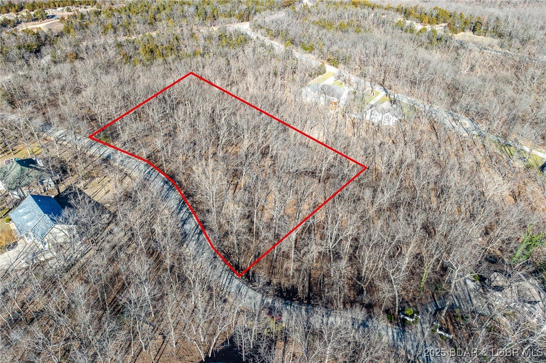 Surrounded by mature trees and natural Ozarks beauty, this wooded lot at The Villages at Shawnee Bend offers a peaceful, private setting within one of Lake of the Ozarks’ most distinguished communities. From the moment you arrive through the grand waterfall entrance, the neighborhood’s upscale character is clear. Residents enjoy access to a beautifully appointed clubhouse, resort-style community pool, championship tennis courts, and pickleball facilities, along with parks, and playgrounds. Paved roads and underground utilities make building seamless while preserving the natural landscape. Ideal for a custom home or lake retreat, this wooded homesite blends serenity, luxury, and an active lake lifestyle.