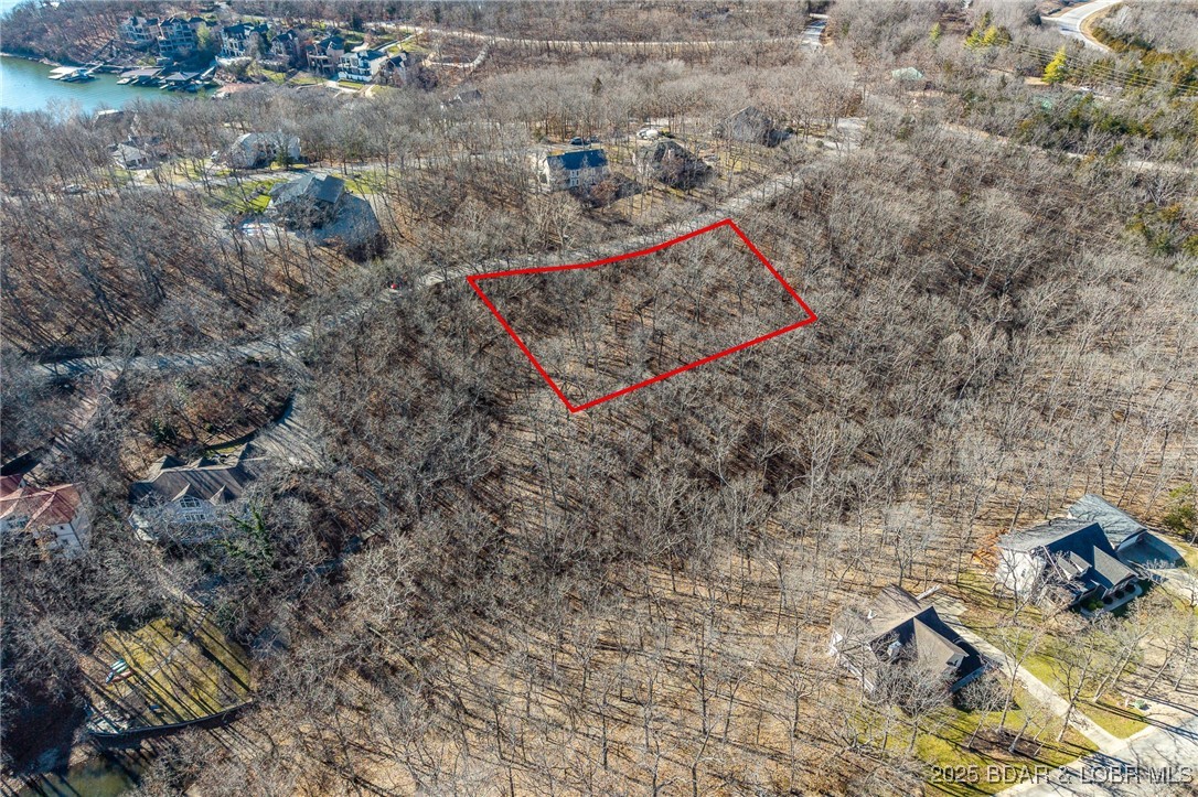 Surrounded by mature trees and natural Ozarks beauty, this wooded lot at The Villages at Shawnee Bend offers a peaceful, private setting within one of Lake of the Ozarks’ most distinguished communities. From the moment you arrive through the grand waterfall entrance, the neighborhood’s upscale character is clear. Residents enjoy access to a beautifully appointed clubhouse, resort-style community pool, championship tennis courts, and pickleball facilities, along with parks, and playgrounds. Paved roads and underground utilities make building seamless while preserving the natural landscape. Ideal for a custom home or lake retreat, this wooded homesite blends serenity, luxury, and an active lake lifestyle.