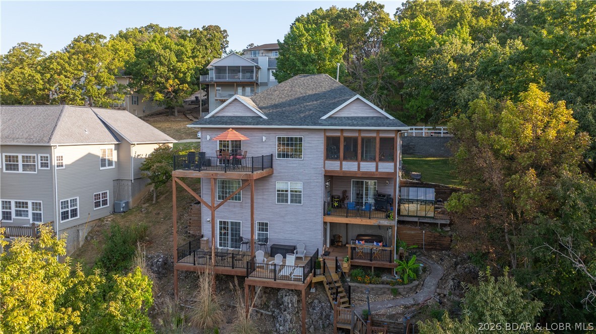 Welcome to Minnowbrook Subdivision, ideally situated on the Big Niangua & just minutes from restaurants, shopping, schools, two premier golf courses, & Ha Ha Tonka State Park. Perched majestically atop a bluff, this exceptional 4-bedroom, 3-bath home showcases breathtaking panoramic lake views that stretch for miles.  Designed to make the most of its spectacular setting, the home features newly remodeled decks on all three levels, a screened three-season room, a hot tub, and a two-person sauna—offering the perfect spaces to relax, entertain, & take in the beauty of the Lake of the Ozarks.
At the water's edge, the concrete dock includes a 16' x 40' slip, two PWC ShorePorts, & a 12' x 20' swim platform for effortless lake days. Inside, expansive lake views are showcased from nearly every room. The main-level primary suite features a beautifully remodeled en suite bath, while three additional bedrooms on the middle level provide comfortable accommodations for family and guests. With stunning views, a thoughtfully designed floor plan, and exceptional outdoor amenities, this home is one you must experience in person, so schedule your private showing today!