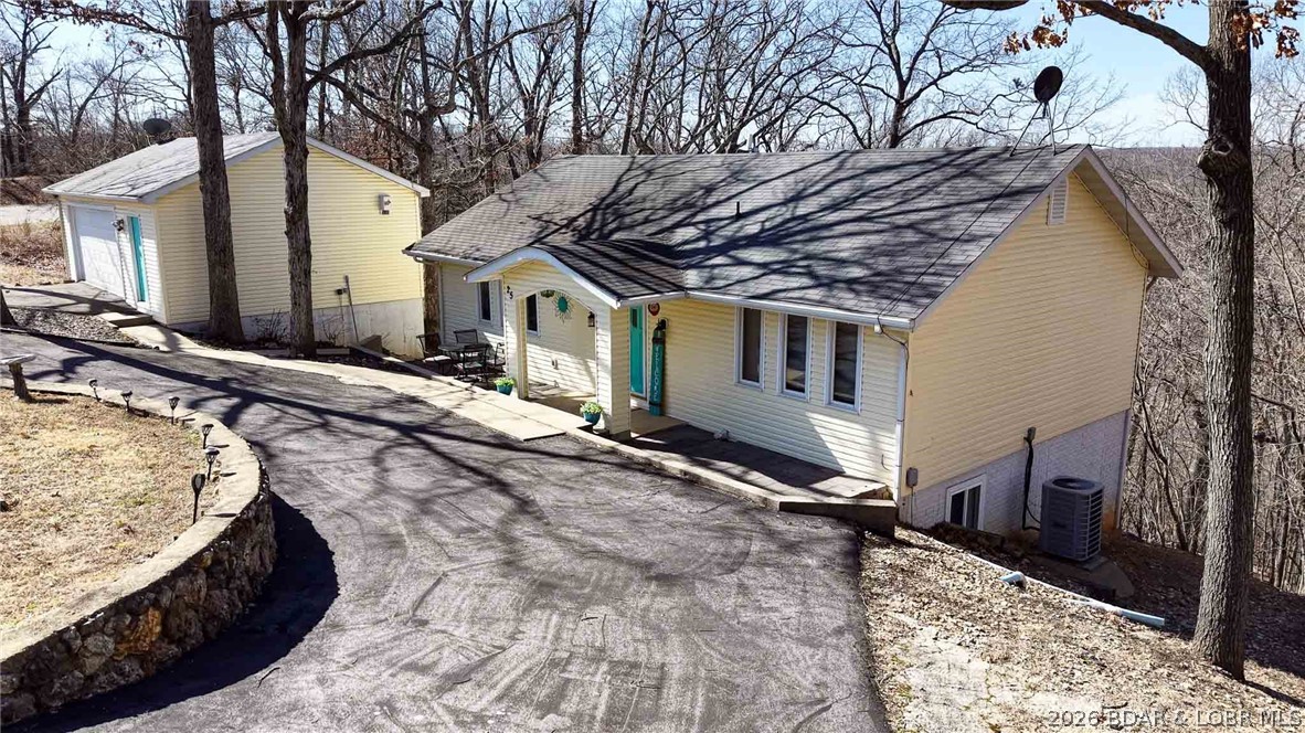 One of the best values currently available under $350K! Offering over 2,000 square feet, 4 bedrooms, 2.5 baths, lake access nearby, & an extensive list of updates already completed, this home delivers far more than buyers typically find at this price point. Much larger than it appears from the street, the flexible layout provides room to spread out while enjoying a convenient location between Camdenton & Greenview in the Camdenton School District. Major improvements have already been completed, including newer septic, lower-level windows, hot water heater, garage door, remodeled kitchen, updated main-level baths, new flooring, screened-in deck, firepit area, & fresh front entry landscaping & pavers. (See attached improvement list.) The expensive projects are already behind you, allowing you to move in & enjoy immediately. A circle drive provides easy access & additional parking, while the large detached 2-car garage offers excellent storage, workshop space, or room for lake toys. With its combination of size, updates, lake access, garage space, & location, buyers searching under $350K should take a closer look before overlooking one of the strongest values currently on the market.