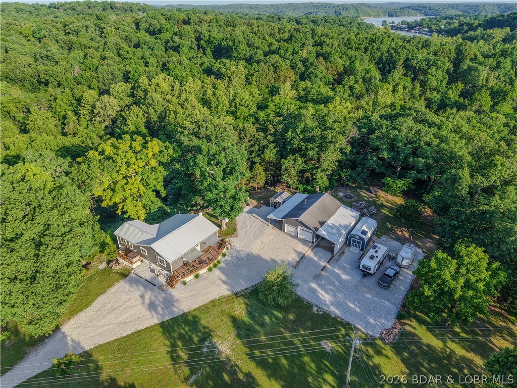 New price on this Lake area retreat on 3 acres with garage/RV setup, updated main level, and lower level income or guest potential. Main level features 2 bedrooms, 1.5 baths, a bright and welcoming large living room, sunroom with pellet stove and Updated kitchen cabinets, butcher block counters and smart appliances. The sellers have taken exceptional care of the home during their ownership, with fresh paint, thoughtful updates, new windows, gutters and a clean, well-maintained feel inside and out. The primary bedroom with half bath and private deck that leads to your hot tub area were you can relax after a day at the lake. The finished lower level adds even more usable space with living area, partial kitchen, exterior entrance, interior access to the main level, and unfinished storage space. A bedroom and full bathroom with washer/dryer hookups in place, makes it easy to rent for some income. Outside, the garage and RV setup are the true standout features with water hookups and 1000 gal septic tank. It includes 24x40 2+car garage, 12x14 carport, 12x26 side garage with auto door and a new chicken coop. Boat ramp access within 2 miles. Schedule a showing today.