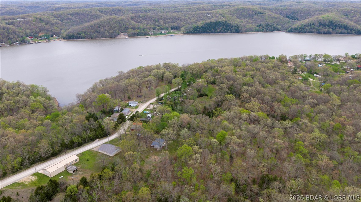 Attention Weekenders and Investors!! We have a perfect opportunity for you to own your slice of heaven here at our Beautiful Lake of the Ozarks. A stone throws distance from the water yet plenty of privacy and room to grow! This property includes a very cute partially remodeled cabin with covered front deck to enjoy the wonderful summer evenings and and listen to the boats go by, it also includes over 4 acres to enjoy hiking, riding atv/utvs or just for future expansion of your dream property. Call today and schedule your showing! THIS ONE IS PRICED TO SELL!
