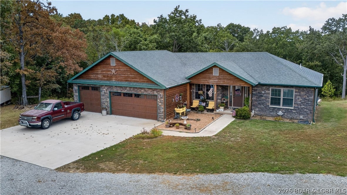 Enjoy the perfect combination of modern comfort, acreage, and plenty of storage with this 3-bedroom, 2-bath Lake of the Ozarks area home built in 2019, situated on 2.07 +/- acres with an impressive 40'x30' detached building. Step inside to a large, inviting living room featuring beautiful wood flooring, abundant natural light, and plenty of space for entertaining. The dedicated dining area flows into a spacious kitchen offering beautiful wood cabinetry, ample counter and cabinet space, and a large pantry. The primary suite provides plenty of room to unwind with multiple windows, a private ensuite bath, and walk-in closet. Two additional generously sized bedrooms complete the living space. Outside, the home features attractive stone and wood exterior accents, a well-maintained yard, and a 40'x30' detached building ideal for vehicles, boats, lake toys, equipment, or workshop space. Located just off paved roads with convenient access to Warsaw, Lincoln, and the Lake of the Ozarks, this property offers the space, location, and versatility you've been looking for!