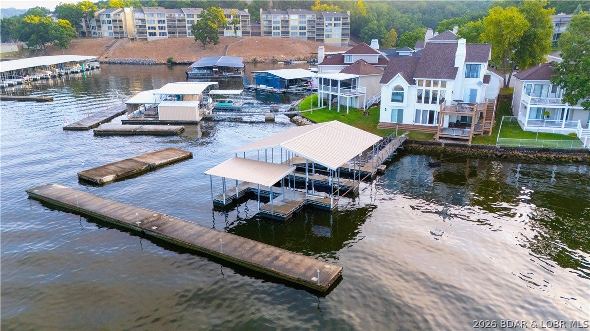 Lakefront living with a FLAT driveway, HUGE views & an unbeatable Osage Beach location! This tastefully remodeled home overlooks the Osage 25 MM and features a NEW roof in Spring of 2026, completely remodeled primary bath in 2025, large breakwater for protected docking & a 2-well concrete dock with 2 PWC spaces. Inside features a vaulted living room filled with natural light and centered around a beautiful gas fireplace, flowing seamlessly into the kitchen & dining area. Enjoy the view from the main-level or lower covered deck perfect for entertaining friends/family! A spacious loft with two full over twin bunks provides flexible sleeping space currently serving as a 4th bedroom + mini-split upstairs. Other updates include rebuilt composite decks (2023), soffit, wrapped front posts, exterior paint, Bosch HVAC, interior sliders & a redesigned kitchen with custom cabinets, countertops, appliances & backsplash. Newer flooring, lighting, plumbing fixtures & updated fireplaces add even more appeal. Perfect for full-time living, lake getaway OR nightly rental! Located in the Camdenton school district, nearby all the Lake's favorite attractions.