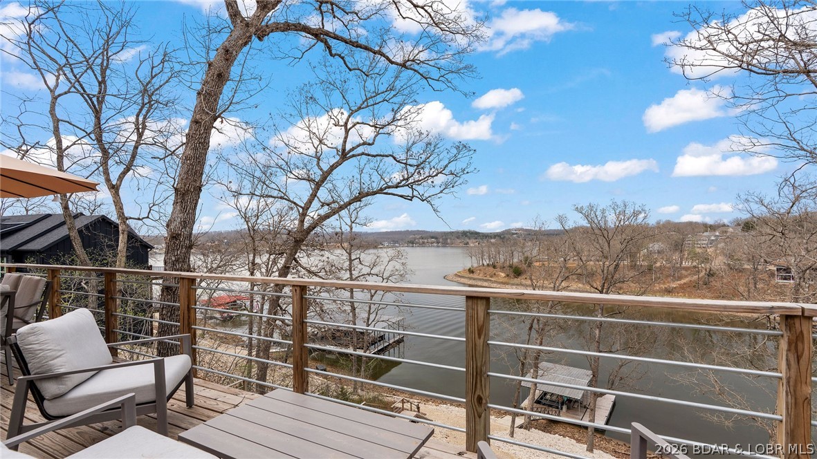 Incredible main channel views with cove protection! Enjoy the best of lakefront living in this beautiful 2023-built 4-bedroom, 2-bath home located in a quiet, protected cove with main channel views. No-wake buoys help keep the water calm, making this an ideal spot for swimming right off the dock while still enjoying the big-water scenery. The home features thoughtful finishes throughout and comes fully furnished and truly turn-key, making it ready for immediate enjoyment. Step outside to a spacious deck perfect for relaxing or entertaining while overlooking the lake. The property includes a fully permitted dock with internet wired directly to the 1-well slip, a path leading down to the water. Boat Lift : 10,000 lb EconoLift with. New bunks and hoses installed in 2024 by Boat Lift Marine Center. A flat open space between the yard and the dock creates the perfect lakefront area for games and relaxing by the water — ideal for playing cornhole and enjoying time with friends and family. What are you waiting for ? Schedule a showing today !