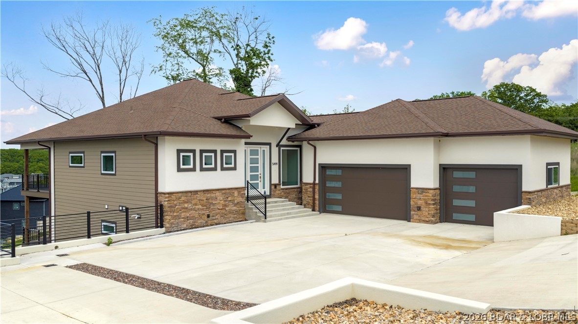5499 Deephaven Lane in Osage Beach blends new construction with a welcoming, cozy lake vibe in the sought-after Harpers Cove community. This beautifully designed 4-bedroom home features 4 private suites, plus a half bath on each level, offering comfort and convenience for both everyday living and hosting at the lake. The open main level showcases vaulted ceilings, wood floors, custom cabinetry, and a bright, airy layout that feels both stylish and inviting. Two levels of covered decks create the perfect setting to soak in the lake view, unwind with morning coffee, or gather with family and friends. With 3,400 finished square feet, one-level living on the main floor, a walkout lower level with additional living space, a 3-car attached garage, community pool and clubhouse access, golf cart path access, and a 14x44 covered slip, this home delivers the relaxed lake lifestyle with the fresh feel of new construction.