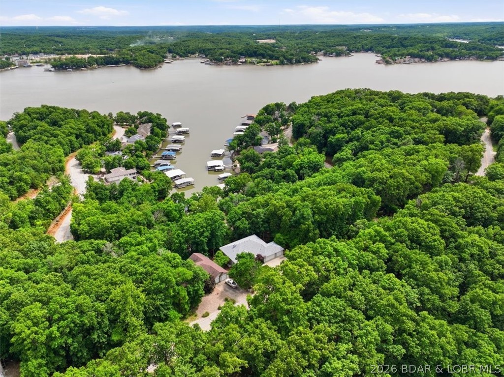 Welcome to this inviting 5-bed, 3-bath home in the highly desirable Four Seasons community, offering beautiful year-round lake views. The main level features vaulted ceilings with ceiling fans throughout, a cozy fireplace, and a living room that frames a fantastic lake view. Enjoy a spacious primary suite, two guest bedrooms, a second bath, kitchen with breakfast bar and nook, separate dining room, and a convenient laundry room. Step out to the large deck—perfect for BBQs, gatherings, or simply relaxing while taking in the scenery.

The finished walkout basement adds two more bedrooms, a full bath, and flexible space ideal for a family room, game room, or office. Sliders open to the backyard and peaceful green space that will never be built on, ensuring your lake view stays unobstructed. Updates include a new HVAC system and new roof. A 3-car garage provides excellent storage with large shelving and tool units. Located just minutes from the Lake Ozark Strip, and enjoying Four Seasons amenities—indoor/outdoor pools, tennis and pickleball courts, playgrounds, lake access, private fishing lakes, campground, trailer parking, and a fitness center— exceptional value and lifestyle.