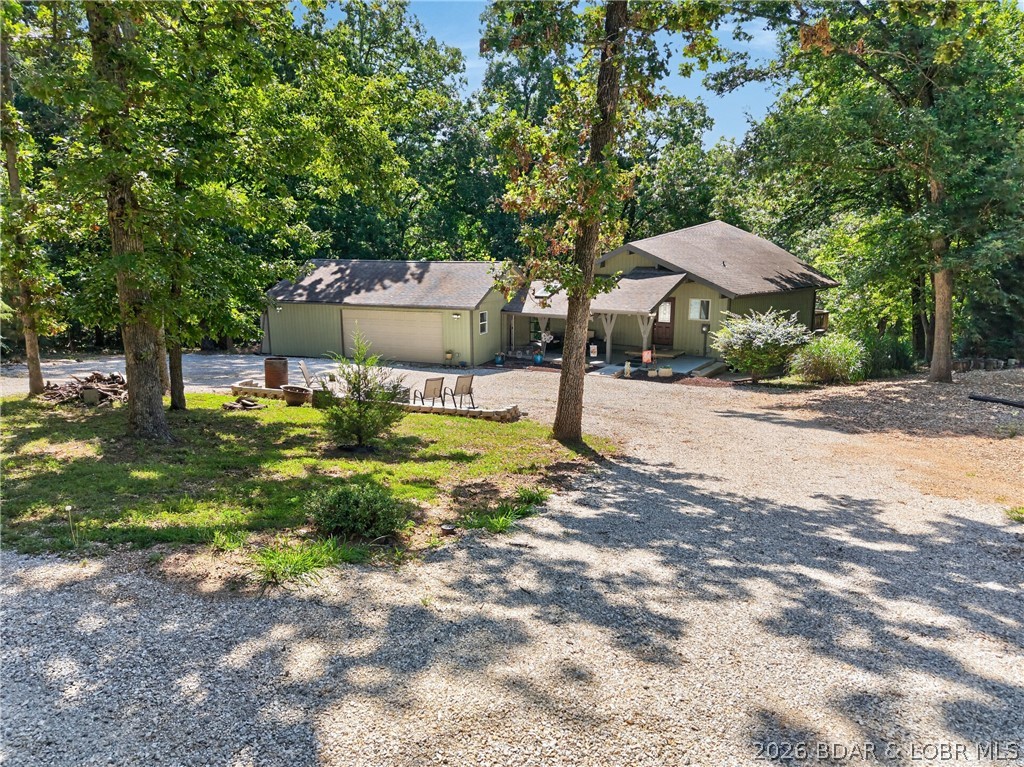 Experience the best of Lake of the Ozarks in this beautifully updated, turn-key home in Gravois Mills. Offering lake access, a boat slip in the community dock, and just minutes from shopping and popular lakefront restaurants by land or water, this home is ready for you to enjoy. Pride of ownership shines throughout, from the welcoming front patio and fire pit to the open-concept living, dining, and kitchen featuring wood beams, wood floors, granite countertops, a large island, and spacious bedrooms. The primary suite includes a loft, perfect for a reading nook, home office, or extra sleeping space. Relax on the expansive back deck or upper deck overlooking the peaceful cove. The oversized garage is heated and cooled with a mini-split system, includes an EV charger, and offers plenty of room for vehicles, golf carts, and lake toys. A whole-house generator provides added peace of mind, and a golf cart path makes the short trip to the dock quick and easy. Being sold fully furnished, this exceptional home is move-in ready—just bring your suitcase and start enjoying the lake lifestyle!