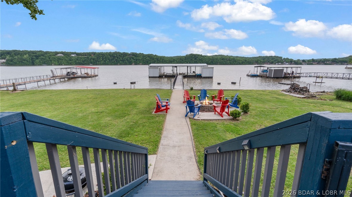 MOTIVATED SELLERS! BRING ALL OFFERS! Wake up to wide-open main channel views and the relaxed pace of lake living in this spacious 4-bedroom, 3.5-bath ranch-style home perfectly positioned at the 49 MM of the Lake of the Ozark. Rare find offering a pancake-flat lot paired with deep water and stunning views. Designed for easy, single-level living, the entire home is laid out on one floor and features two private master suites on opposite sides of the home. The large, open kitchen offers abundant cabinetry and flows seamlessly into the main living areas. One-of-a-kind enclosed tiki bar on the spacious deck as well as a fishing storage closet . Enjoy approximately 100 feet of gentle lake frontage, a fantastic view, and a private dock with three 12x30 slips. The property also includes newer French doors that enhance the home’s charm, a fenced yard, a 10’x12’ garden garage, greenhouse, and two additional storage sheds. 6-car detached garage with heating and cooling, plus a 2-car attached garage. Above the detached garage, a 60’x32’ finished upper level with HVAC provides additional flexible space. New Roof in 2023. A true rare lakefront retreat offering space, functionality!