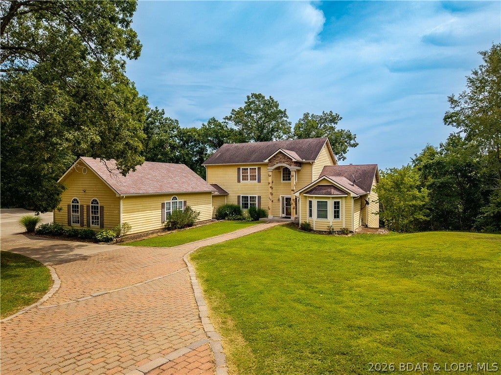 200 Keigan Dr, Eldon, MO—14+ acres, TWO residences, massive parking, and endless possibilities near Lake of the Ozarks! Tucked high in the hills with scenic views and paved-road access, this unique property offers the space and flexibility that are hard to find this close to Lake Ozark and Eldon. The main home features approx. 4,800 TOTAL sq ft with 5 bedrooms, 4 baths, three levels of living, an open-concept kitchen/dining area, finished lower level, fireplace, and spacious deck. A separate 1-bedroom, 1-bath guest home with its own garage creates an outstanding opportunity for rental income, extended family, guests, or a private home office. Both homes have garage parking, but the real bonus is the HUGE concrete parking area between them—large enough for two pickleball courts! Think boat and trailer parking, RVs, multiple vehicles, basketball, outdoor entertaining, or space for all your Lake toys. With 14.3 acres of open and wooded ground, privacy, room to roam, and approximately 15 minutes to Lake Ozark and Eldon, this property offers acreage, income potential, and versatility in one exceptional package.