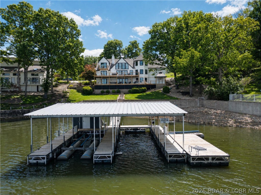 A remodeled masterpiece! This extraordinary waterfront home has been taken down to the studs and completely reimagined with new LP smart siding, windows/doors, HVAC units, flooring, and drywall. Finished with custom steel railings, built in bunk bunks, designer lighting, and spa like bathrooms. On the main and lower levels, two sets of ~12 ft custom slider doors showcase the impeccable main channel views. Situated directly across from Four Seasons for a front row seat to the lakes best fireworks display. Enjoy the gentle sloping double lot with your own private beach and room for a pool. Furniture included and NO HOA (short term rentals are allowed). To complete the package, a three-car garage and expansive circle driveway with ample parking. This is luxury living at its finest - built to impress!
