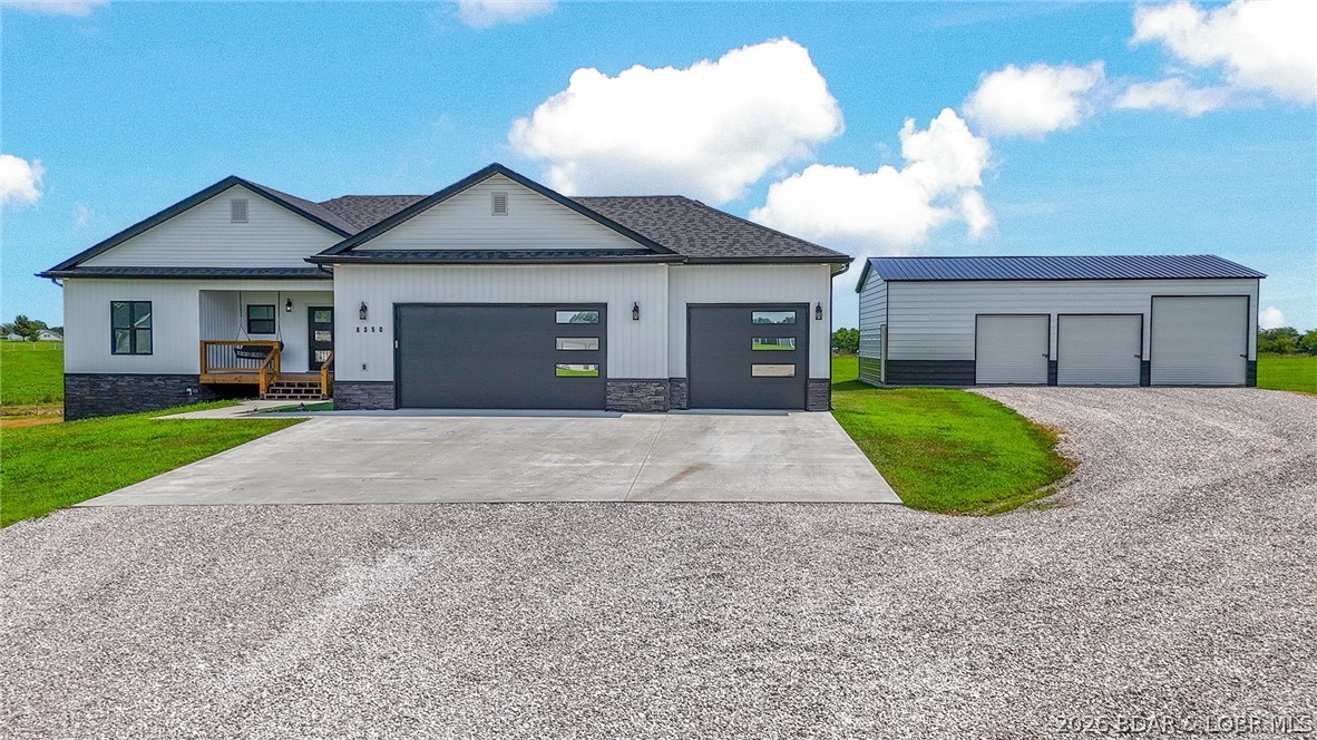 Custom-built home on 5 acres offering 3,837 sq ft with 4 bedrooms, 3.5 bathrooms, 2 offices, a large bonus room, and an attached 3-car garage with extra-tall ceilings. The open floor plan features spacious bedrooms, heated bathroom floors, a soaker tub, private deck access from the primary suite, quartz countertops, a walk-in pantry, and quality finishes throughout. The finished basement includes 10-ft ceilings, a wet bar with quartz island, butcher block shelving, mini fridge, wine cooler, a dedicated gym area, and a bonus room with a 4K home theater featuring a 160" screen and surround sound. A 17x12 concrete safe room with 8" concrete walls, a reinforced concrete ceiling, vault door, and emergency hatch offers exceptional security and storm protection. Outside, enjoy a 40x24 detached shop plumbed for future utility use with four garage openings, including tandem rear access. This thoughtfully designed property combines luxury, functionality, and privacy in a beautiful country setting. Seller is willing to sell select personal property separately.