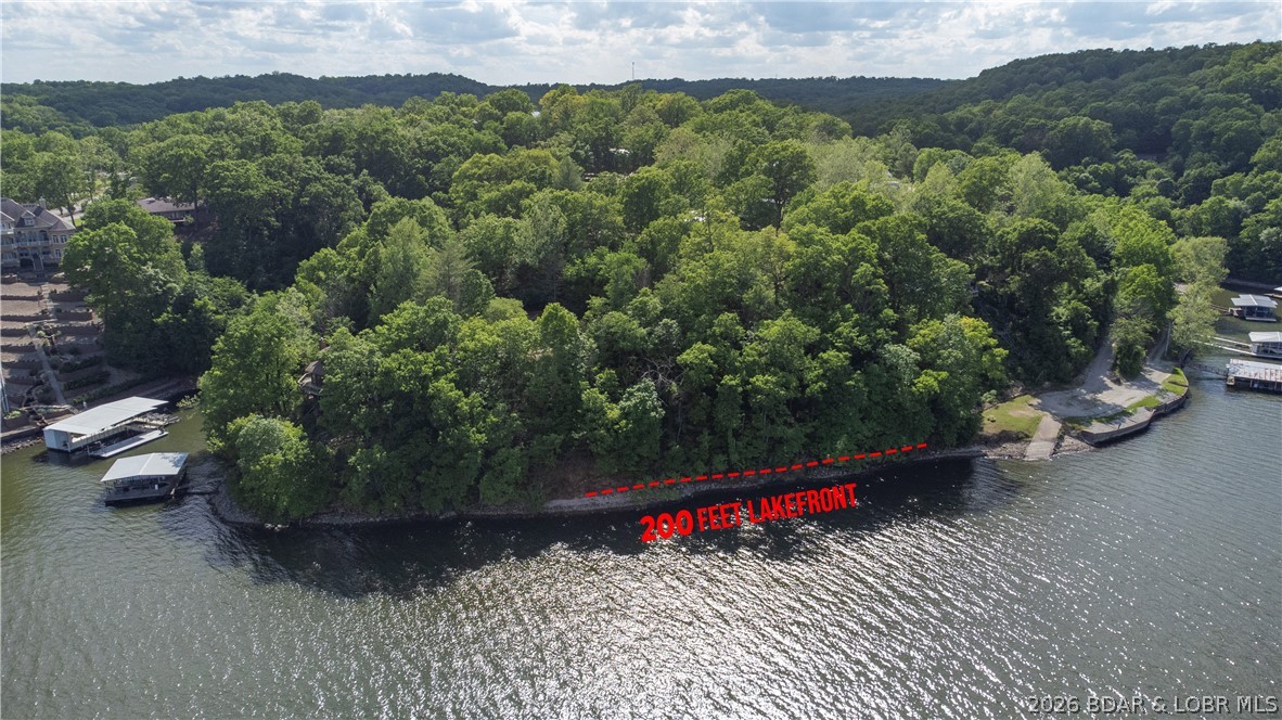 Enjoy over 200 feet of lakefront with deep water, expansive main channel views, and an exceptional location at the 33MM off Lake Road 5-61. Conveniently situated just minutes from both Camdenton and Osage Beach via the community bridge, this property offers the perfect balance of privacy and accessibility. By water, you're only moments from some of the Lake's most popular waterfront destinations, including The Cave Bar & Grill, Captain Ron's Bar & Grill, Bear Bottom Resort, Larry's on the Lake, The Fish and Company, Paradise Tropical Restaurant & Bar, and Nauti Fish Rum Bar. Whether you're looking for a full-time residence, vacation getaway, or investment opportunity, this prime lakefront setting offers everything that makes Lake of the Ozarks living so desirable.
