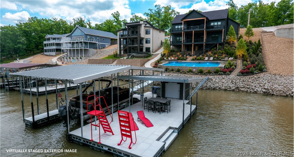 Whether you are enjoying a rainy afternoon on the covered decks, hosting friends at your dock, or exploring nearby favorites like Fish & Co., Bulldogs, or Nauti Fish, this custom-built lakefront ranch is the ultimate getaway. Completed in mid-2025, this home is tucked away in a quiet, year-round deep-water cove. Designed for living & entertaining, main level open concept features 2 bedrooms, including a primary suite w/ a dreamy oversized walk-in closet. The chef’s kitchen is equipped w/ an awesome walk-in pantry for all your storage needs, a wine/beer fridge an island seating space perfect for holiday hosting or Sunday Fundays. Enjoying watching games on the covered deck TV & gas line for grilling. A massive family room anchors the lower level, complete w/ wet bar, built-in ice maker & 2 additional bedrooms. The 2.5-car garage includes a workbench area & room for 2 cars plus a side-by-side. Built for lake life, golf cart path leads you to the entertaining dock features a built-in bar & large swim platform. If you want to add a pool there it has the perfect backside space, see virtual picture.   The home comes partially furnished for immediate enjoyment. Come check out the sunsets.