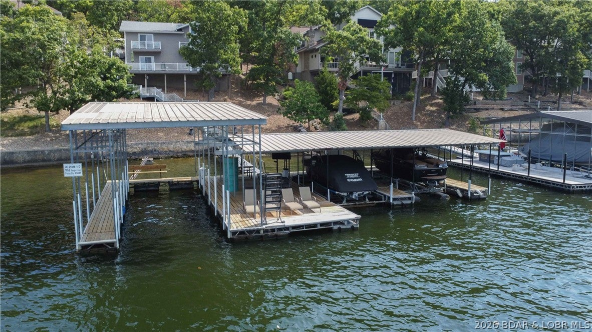Located in the highly desirable Village of Four Seasons at the 7-mile marker, this 5-bedroom lake home offers an incredible combination of location, views, space, & lakefront amenities. Enjoy beautiful main-channel views & gorgeous sunsets from your private patio. With two full kitchens, this home offers exceptional flexibility for large families, multi-generational living, entertaining, or hosting guests. Outside, the property truly shines w/ a huge 3-well dock, providing plenty of room for boats, water toys, & lake-day entertaining. The convenient location provides easy access by both land & water, putting you close to area restaurants, shopping, golf, & all the attractions the Lake of the Ozarks has to offer. Whether you're looking for a full-time residence, weekend getaway, or investment opportunity, this home provides the space & setting to enjoy lake life year-round. With the furniture and boat lift included, you can make this home your own and start enjoying it immediately.