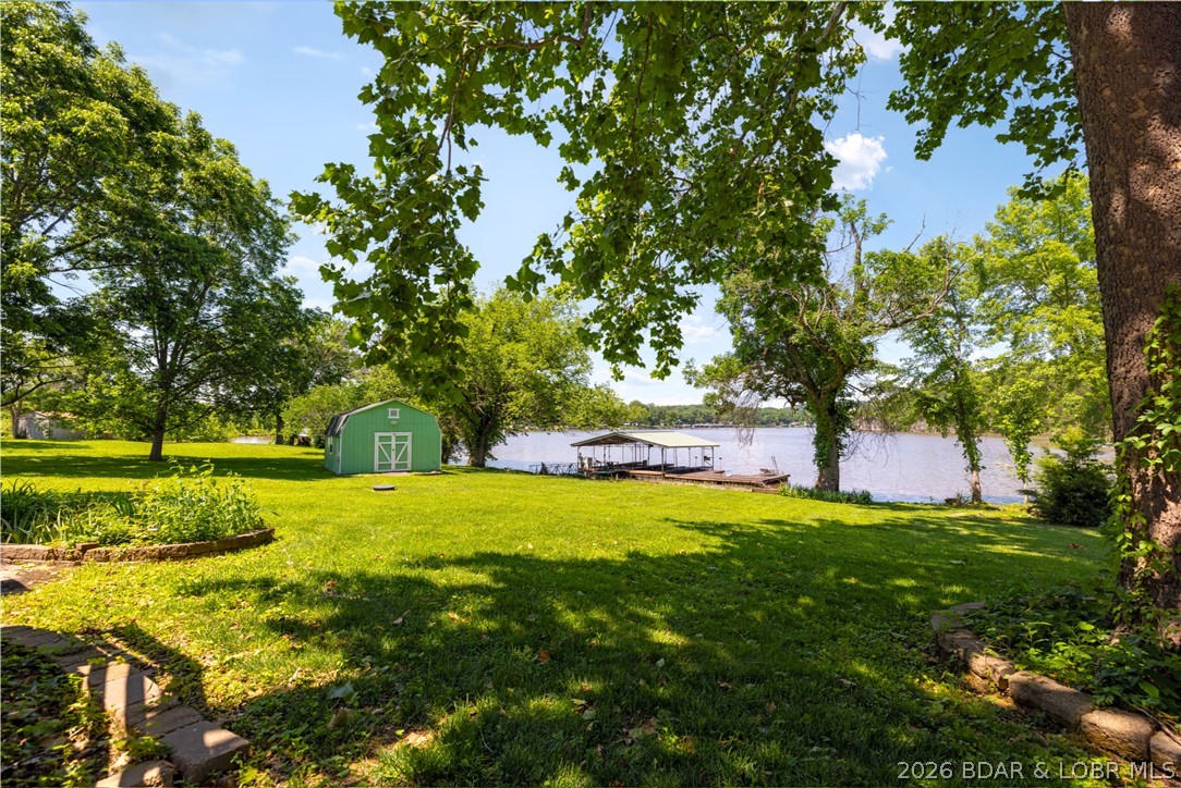 Tucked along the Big Niangua in Whispering Valley Estates, 73 Whisperwood Drive brings together the warmth of a true log home with the easy rhythm of lake life. Set on a flat .82-acre lakefront lot with 133 feet of shoreline, this 5-bedroom, 3-bath retreat offers space to gather, unwind, and enjoy every season at the water. Inside, wood details, a cozy fireplace, sunroom, and walkout lower level create a comfortable lake-home feel, while new Anderson windows, new exterior doors downstairs, and a new sliding glass door add thoughtful updates. Outside, enjoy the deck, patio, attached swim dock, 2-well dock with boat hoist, 24x16 storage shed, 20x20 carport, plenty of parking, and a community boat ramp just one house down. With rentals allowed, this property is ready for weekends, full-time living, or investment potential.