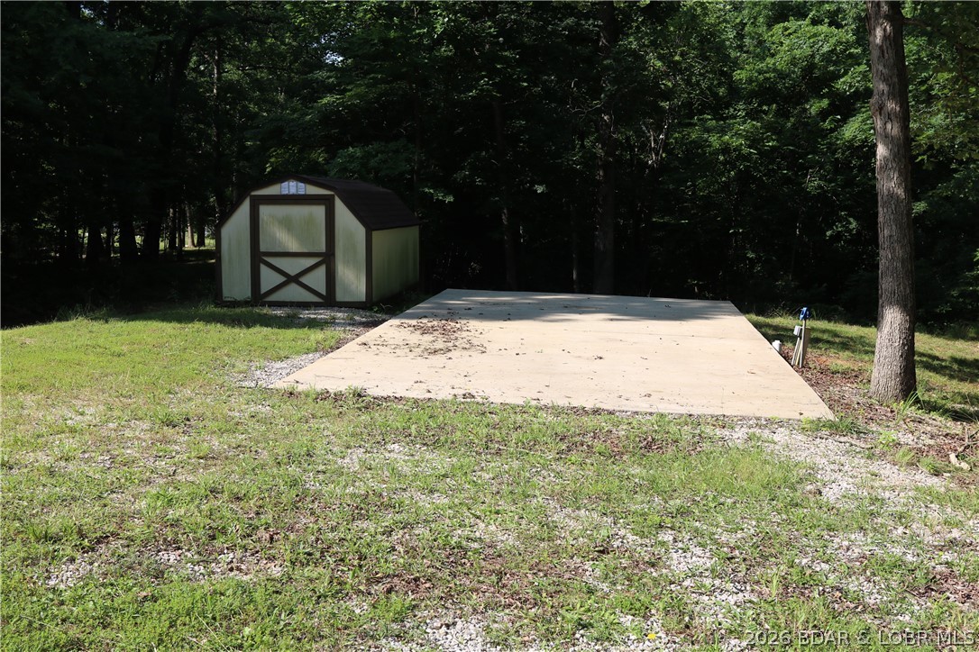 Inexpensive way to enjoy beautiful lake of the Ozarks. New concrete pad poured for the trailer and added space for outdoor entertaining and outdoor cooking and fun. Nice large Cleared Lot walking distance from the beautiful Lake of The Ozarks. Sellers have installed new septic system. Community water and electric already hooked up as well. Storage shed on property as well. This is a great way to come enjoy what the lake has to offer at the quiet 60 mile mark. Patriots Point marina just a short distance down the road to possibly rent a boat slip.  Patriot point is very convenient and full service clean and neat destination with large general store boat, ramp and gas sales for your boat.