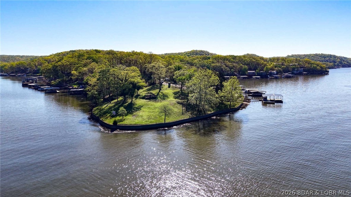 Extremely rare opportunity to acquire a lakefront point property offering approximately 500 feet of premium shoreline with panoramic main channel views and protected cove frontage. This level to gentle lot provides an ideal building site for a luxury lakefront estates, private retreat or lakefrnt development opportunity. It includes a stone seawall, electric is available, and the site offers a previous boathouse. Positioned in a prime area near the "Four Corners" by water, if offers quick access to lakefront dining, marinas, boats and entertainment, while maintaining privacy with a gated entrance and blacktop roads access nearly to the property. Great development opportunity for developers/ builders with a survey in place and marks in place for subdividing. There is a large demand for lakefront homes and new construction. Please call Agent for more details. Property is gated-will need access.