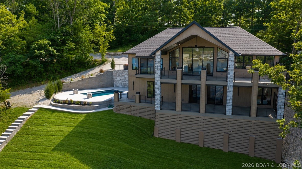 Luxury lakefront living w/ high-end finishes, exceptional outdoor spaces, & ability to nightly rent. This 5BR, 5.5BA home offers 3,800SqFt & is offered fully furnished. The design is highlighted by ~13ft ceilings in the living room & an 11ft Quaker aluminum sliding door that fully retracts, seamlessly connecting to the covered lakeside deck sporting massive lake views. The chef's kitchen features quartz countertops, gas range, custom range hood, dual refrigerators, SS appliances, & a butler's pantry. The main level also includes the primary suite, guest bathroom, & laundry, while the lower level offers a second entertainment space, four more bedrooms, four bathrooms, a second laundry room, & a game/lounge room featuring built-in queen bunk beds. Outside, the nearly $450,000 gunite pool w/ fire bowls & dock package creates the ultimate lakefront experience. The new dock includes a 16x44 slip, 12x34 slip, dual PWC slips, and huge swim platform. More highlights include two levels of composite decking, cove location w/ calm water, a flat driveway, insulated garage w/ mini-split, plentiful shoulder street parking, & premium Diamond Kote LP SmartSide siding. View this today!
