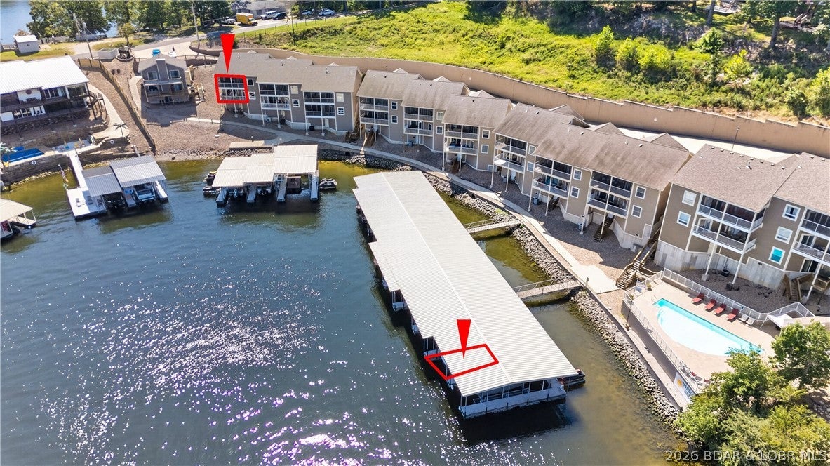 Why settle for an ordinary condo—or pay substantially more for a comparable lakefront home—when this beautifully maintained townhome delivers the space, quality & convenience of both? Located at the 1 Mile Marker with spectacular views, this furnished 3-br, 2.5-bath residence offers exceptional value in one of the lake’s most convenient locations. The open kitchen features beautiful cabinetry, granite countertops, a double oven and pantry. Vaulted ceilings continue into the spacious living room & impressive primary suite, which includes access to the upper deck and a private bath with tub & walk-in tile shower. The lower level provides another large family room, wet bar and access to a second expansive deck. Fresh carpet, attractive paint colors, quality furnishings & immaculate condition make this property move-in ready. 2 car attached garage, plus a 12x36 boat slip in the shared community dock. Hop on the golf cart and ride from the garage to the pool/dock, or continue to the Bagnell Dam Strip for nearby shopping, dining and entertainment. Exceptional space, outstanding condition, garage, large slip and a premier location—this is lake living without the lakefront-home price tag!