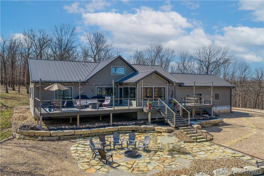 Custom-built waterfront home on approximately 5 acres +/- at the 75 mile marker of Lake of the Ozarks offering 4 bedrooms and 3.5 bathrooms. Two bathrooms feature large walk-in tile showers with bench seating and one includes a shower/tub combination. The open living, dining, and kitchen area features wood flooring, vaulted wood ceilings with exposed beams, and large windows providing natural light and views of the surrounding landscape. The kitchen includes a 9-ft island with seating, quartz countertops, custom cabinetry, stainless steel appliances, and a walk-in pantry. Main level also includes an office, sunroom, laundry room, mud room, and attached 2.5-car garage. Lower level offers a game room with pool table included, two bedrooms, and a full bath. Approx. 110ft of waterfront with electric tram to a private two-slip dock with lifts and swim platform. Located in Forbes Lake of the Ozarks Park.