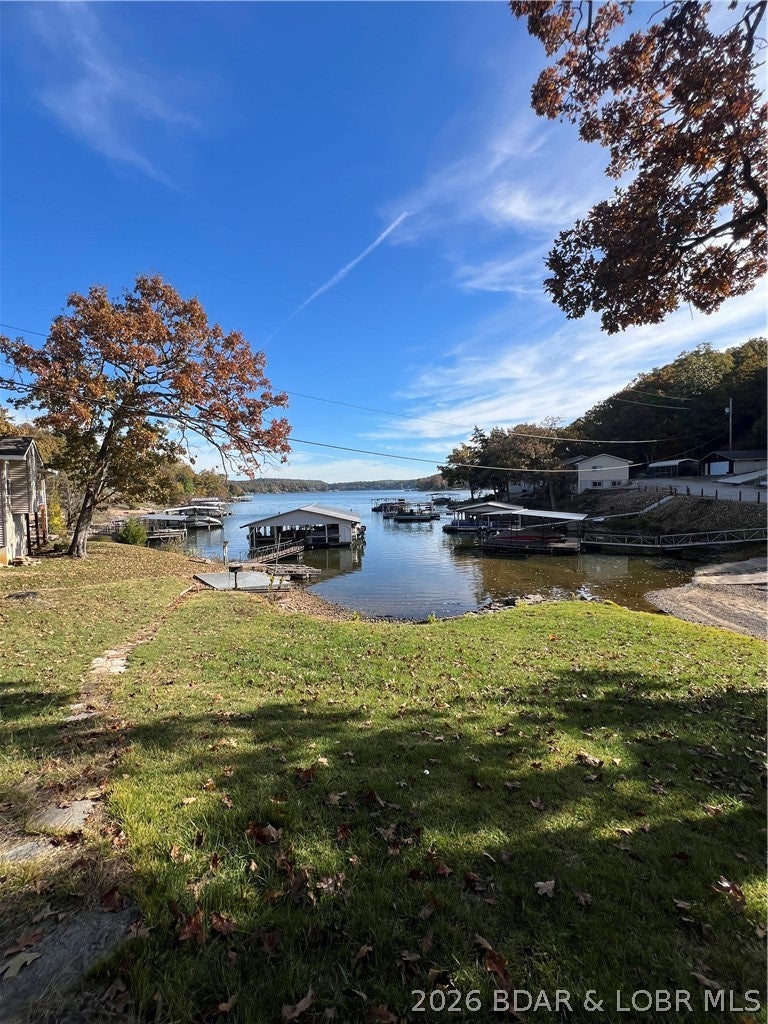 Enjoy peaceful lakefront living in this 1,896 sq ft home nestled in a quiet cove on the Little Niangua Arm at the 1 MM of Lake of the Ozarks. This 3-bedroom, 2 bath residence offers comfortable year-round living or the perfect weekend retreat. Shared road maintenance, community well, and dock access make ownership easy and affordable. The property includes access to a community dock, ideal for fishing or swimming just steps away. If you are looking for a lakefront FIXER UPPER  located in a quiet cove, this property is for you! Call for a private showing today.