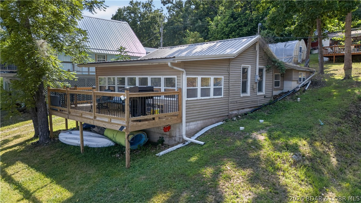 Lake of the Ozarks getaway with proven income potential just minutes from Warsaw! This beautifully updated 2-bedroom home is currently operating as a successful Airbnb, making it an excellent investment or personal lake retreat. Enjoy beautiful lake views from the front porch and spend your days on the platform swim dock, perfect for tying up the boat, swimming, fishing, and relaxing on the water. Inside, you'll find updated flooring, a remodeled kitchen, and inviting living spaces designed for entertaining family and friends. The bright sunroom is filled with natural light and offers peaceful lake views, creating the perfect place to unwind. There is also a community boat ramp a stones throw from house! Conveniently located close to Warsaw, you'll enjoy easy access to shopping, restaurants, and local amenities while still experiencing the peaceful lake lifestyle. Whether you're searching for a weekend escape, full-time residence, or turnkey short-term rental, this Lake of the Ozarks property is ready to enjoy.